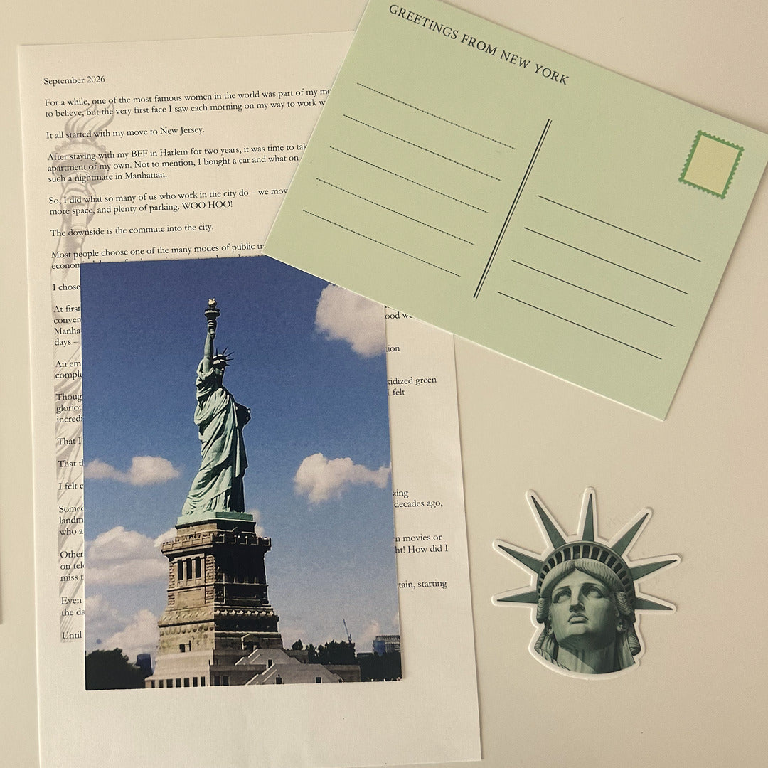 Inside the October 2026 Gotham Girl envelope: the letter, a Statue of Liberty photo print, a Greetings from New York postcard and the Liberty sticker